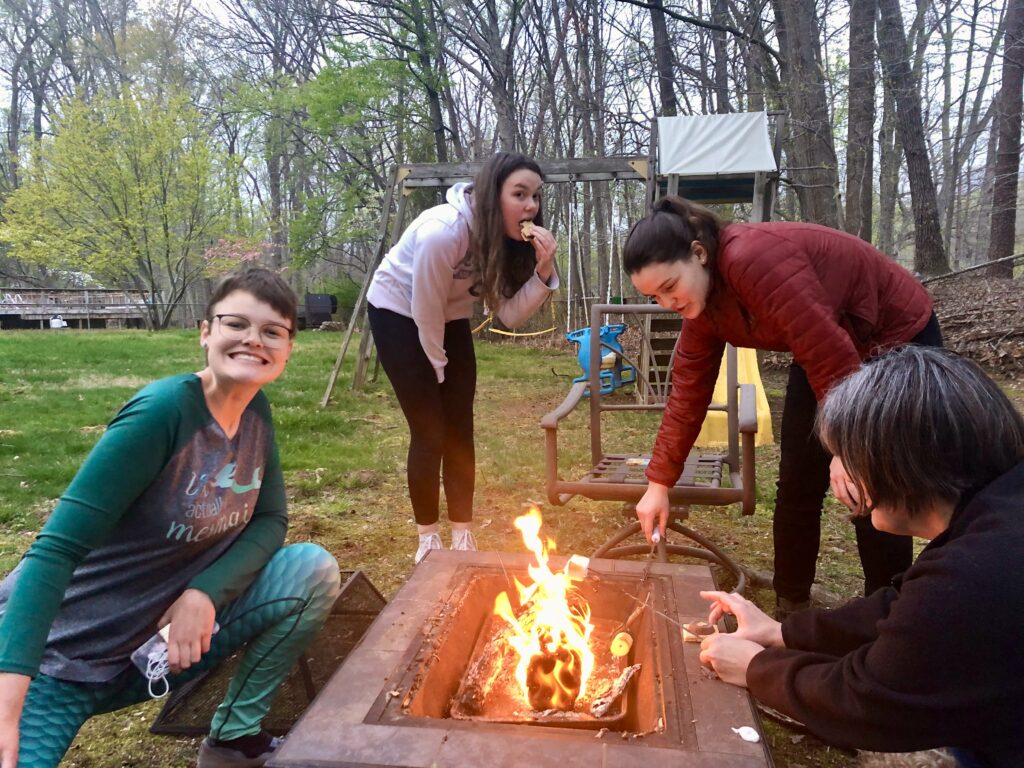 A group of people standing around a fire

Description automatically generated